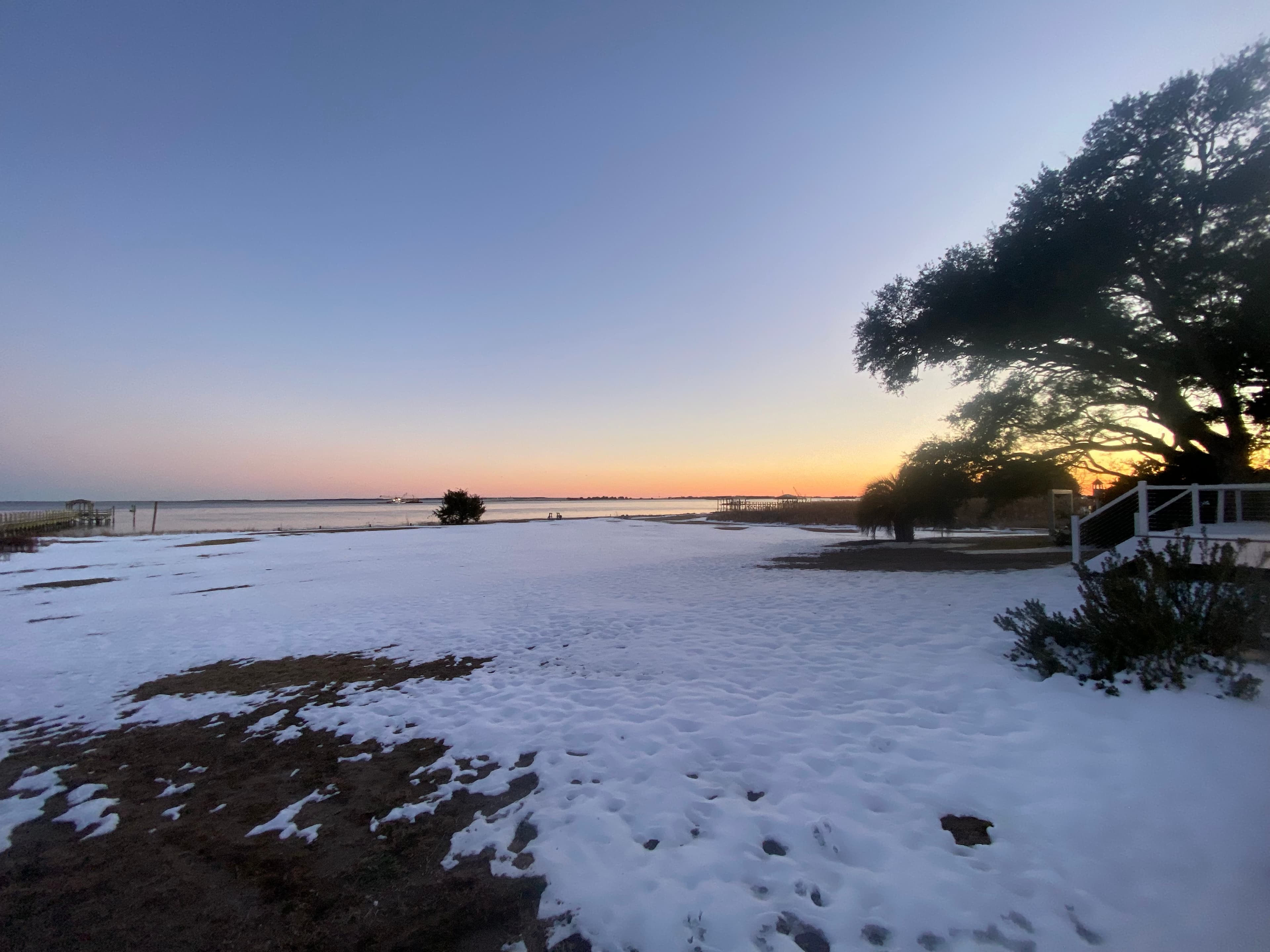Snowy coastal sunset with dock